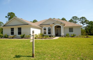 white and brown concrete bungalow under clear blue sky
